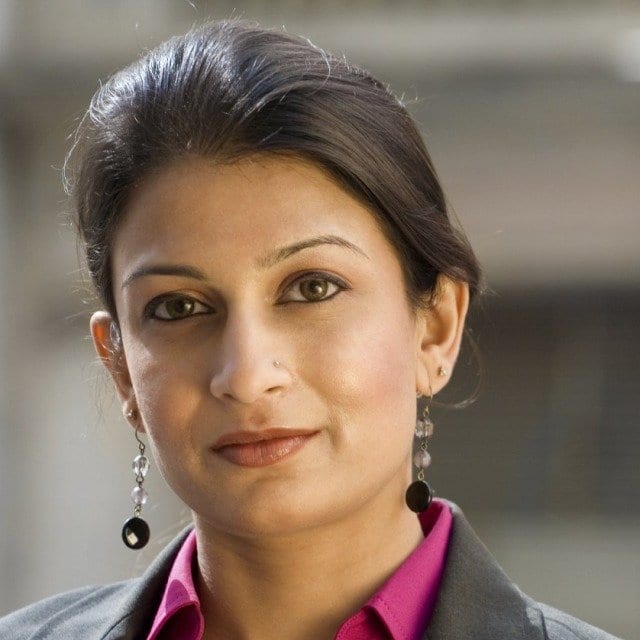 Profilbild von Andrea Lauerer. Sie trägt eine brombeerfarbene Bluse und dunkles, zurückgebundenes Haar.