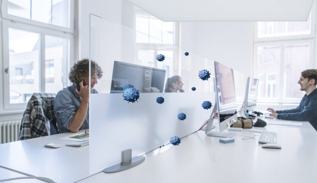 Trennwand mit Virenbildern trennt zwei Personen im hellen Büro.