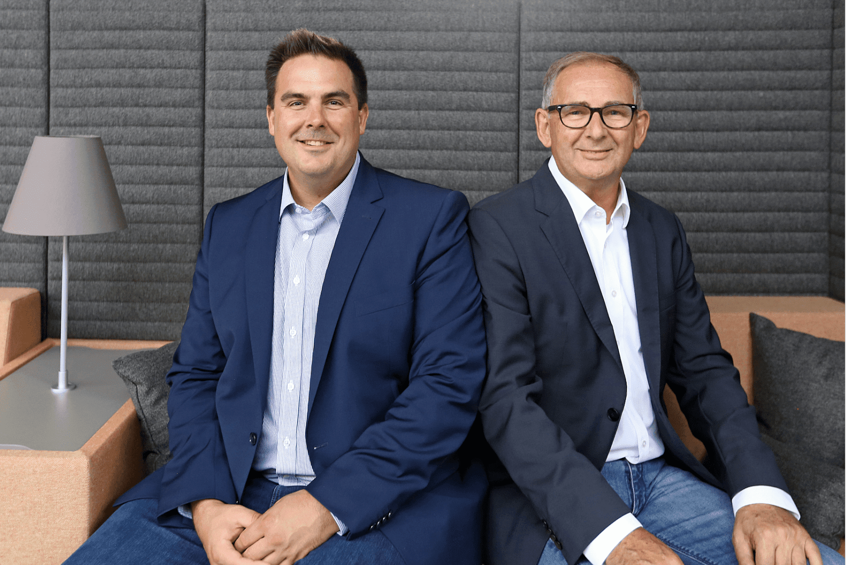 Lech Männer in Business-Anzügen sitzen in einem modernen Bürobereich.