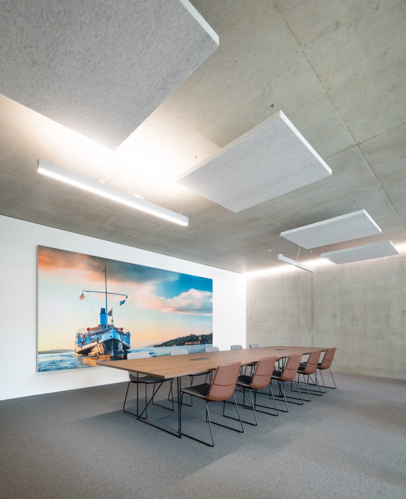 Moderner Besprechungsraum mit Akustikdecken und großem Wandbild.
