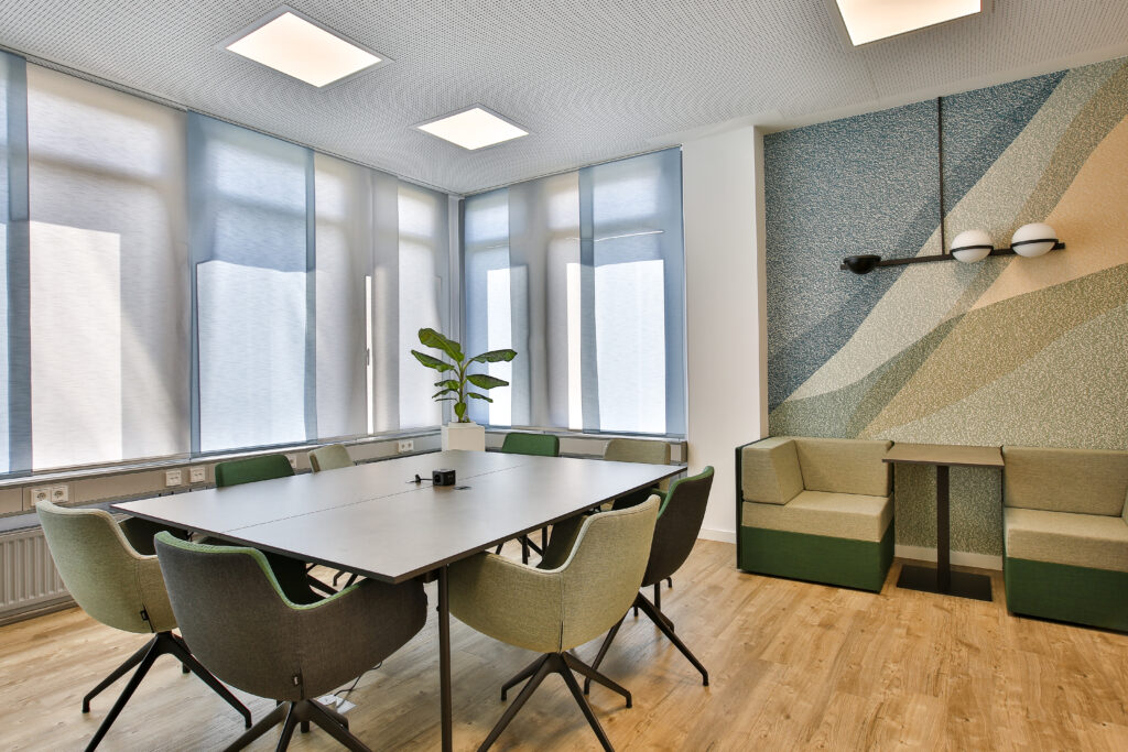 Moderner Besprechungsraum mit großem Tisch, Stühlen und Akustikdesign an der Wand