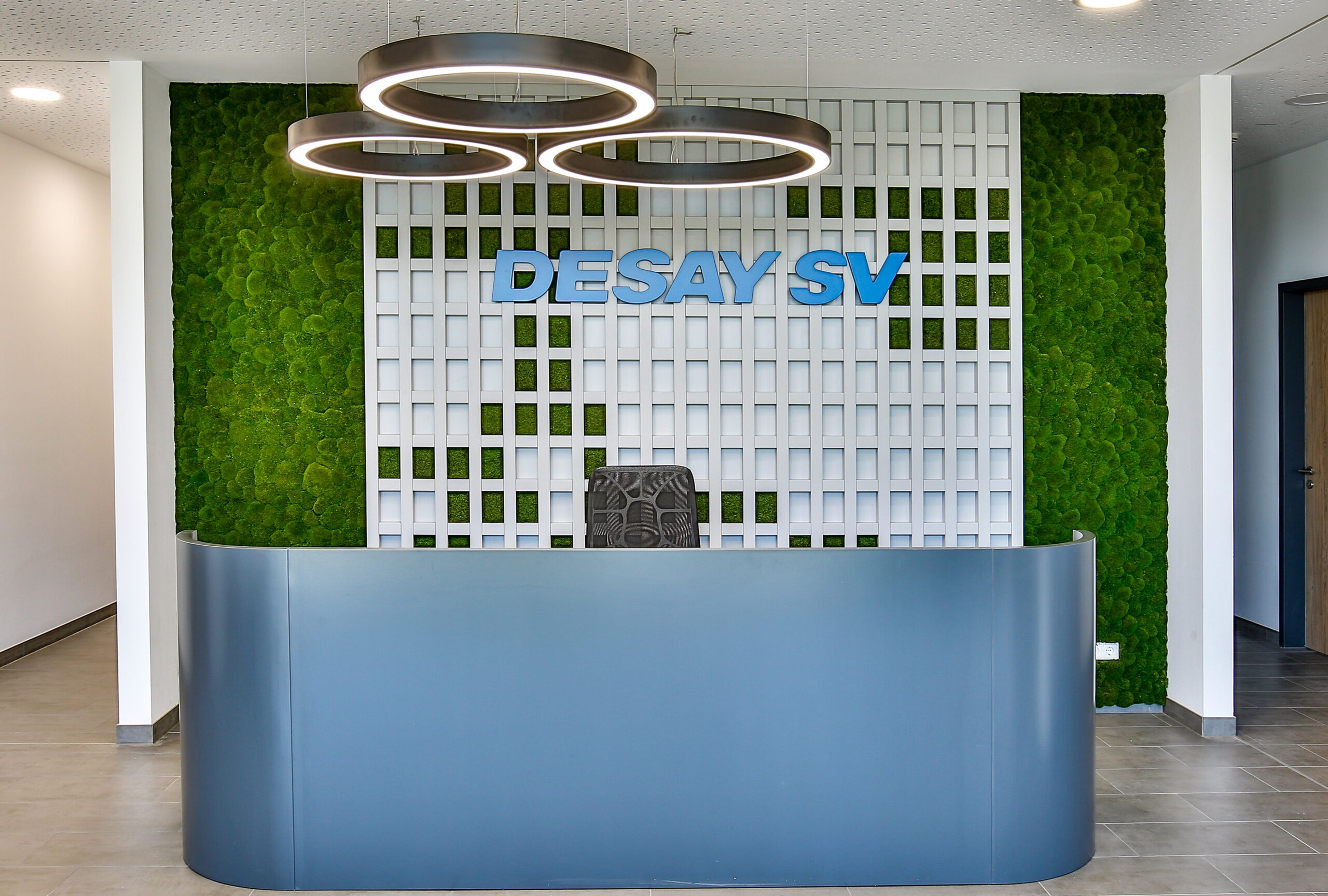 Empfangstheke mit Mooswand und Logo im Büro von DESAY SV in Weimar